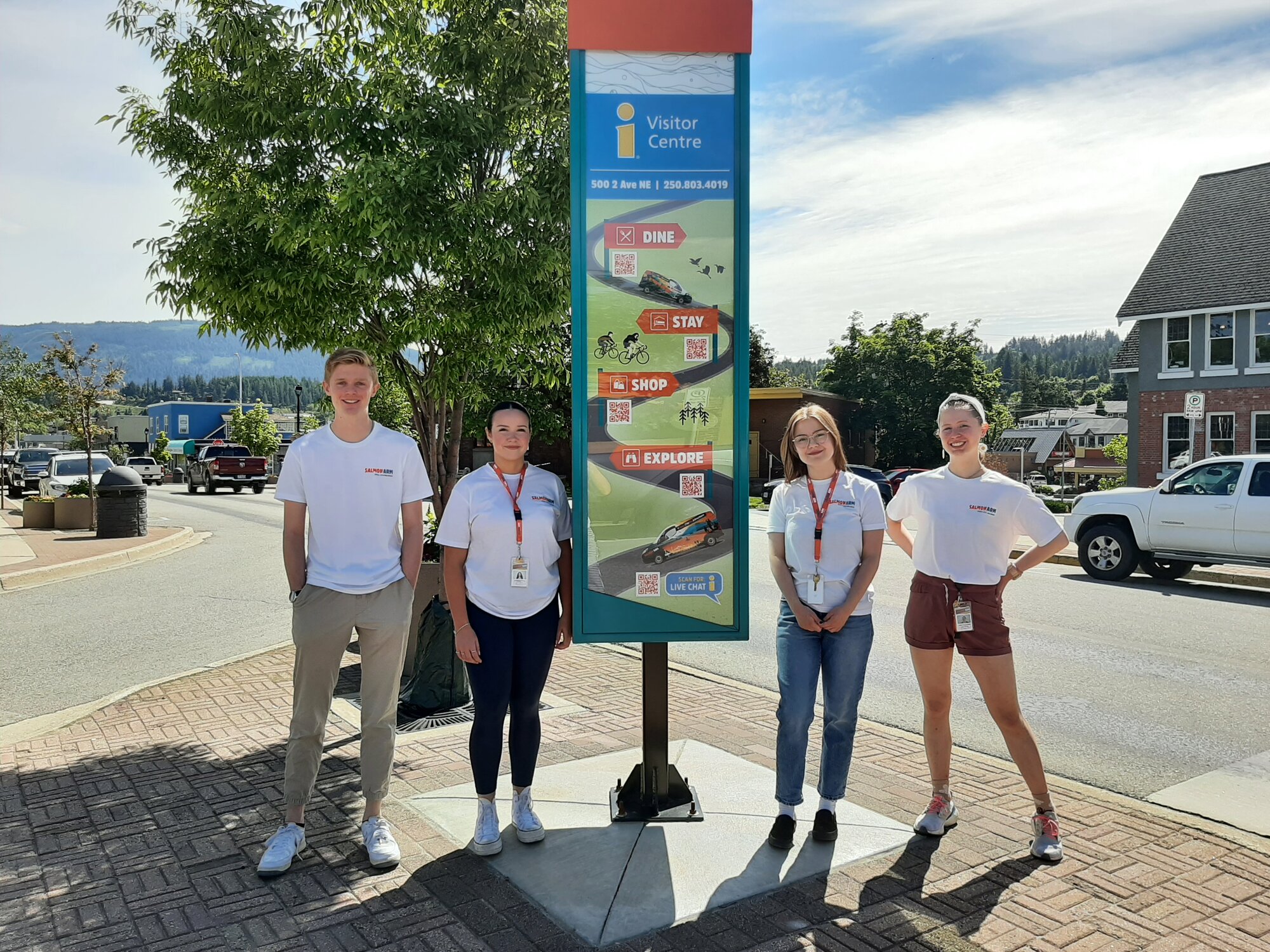 Tourism ambassadors beside the downtown Visitor Centre wayfinding pillar on Ross Street