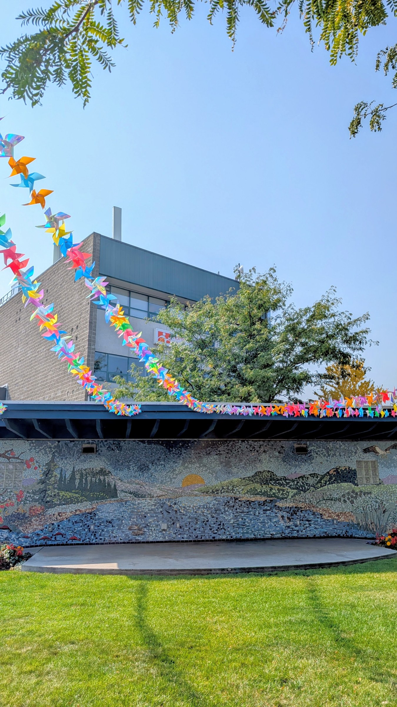 Colourful paper-crane bunting strung above the downtown mural amphitheatre
