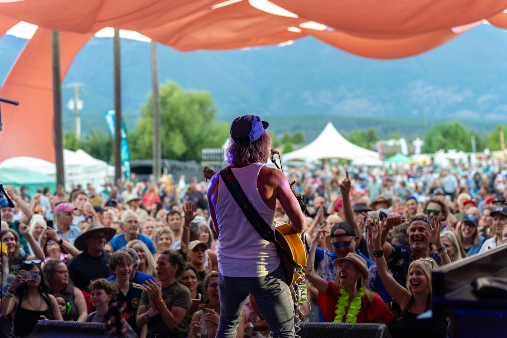 A musician on stage facing a packed Salmon Arm crowd